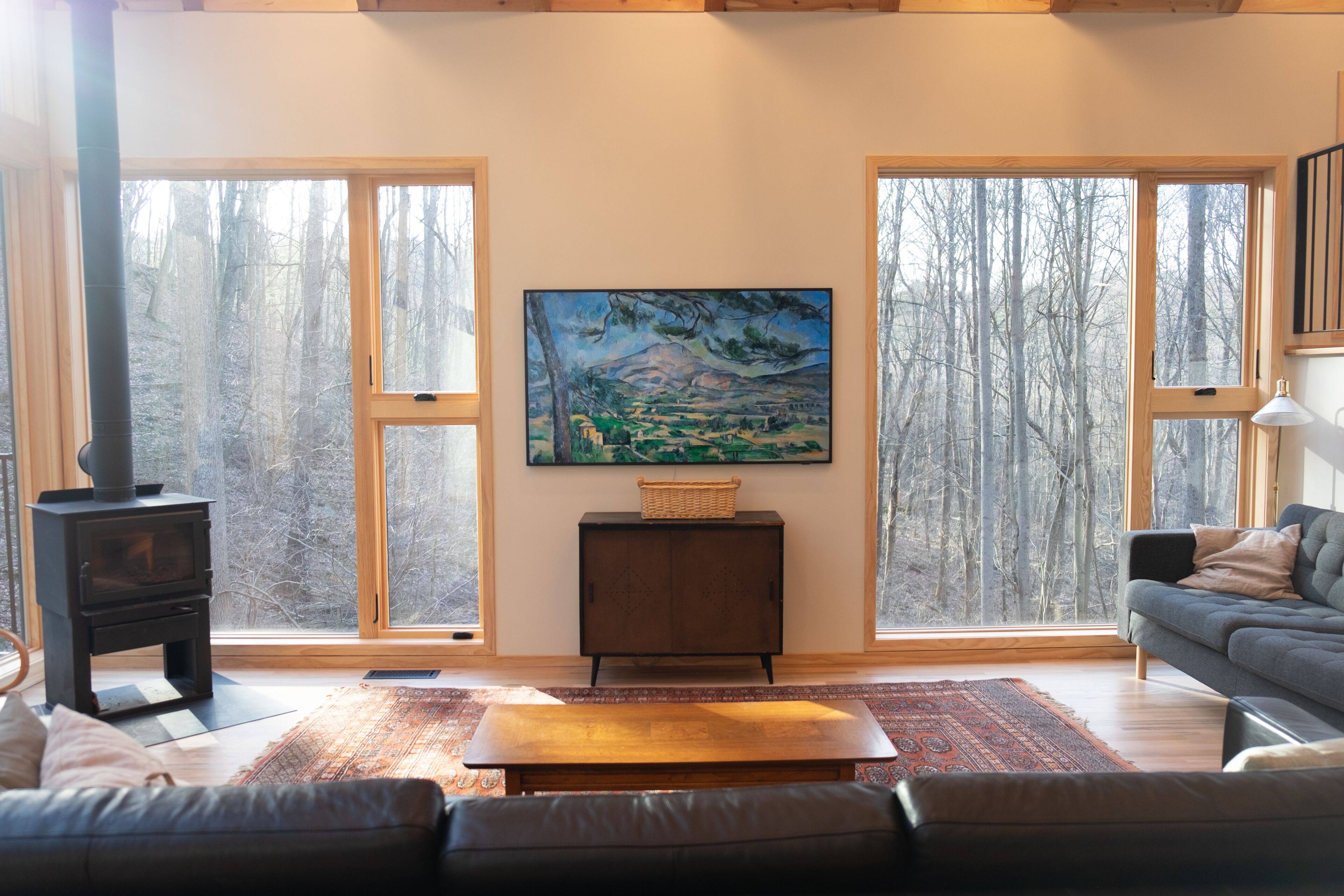 A cozy living room with a fireplace, a sofa, a coffee table, and a painting on the wall.