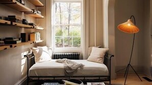 A bedroom with a bed, bookshelves, a window, and a floor lamp. - Serene Estate: Heated Pool, Tennis, Sauna, Hot Tub (Catskill)