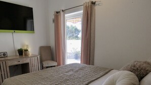 Une chambre à coucher avec un lit, un bureau, une chaise et un téléviseur fixé au mur.