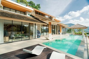 A modern house with a swimming pool, large windows, and a view of the mountains. - Chateau Du Village Patong (Patong)
