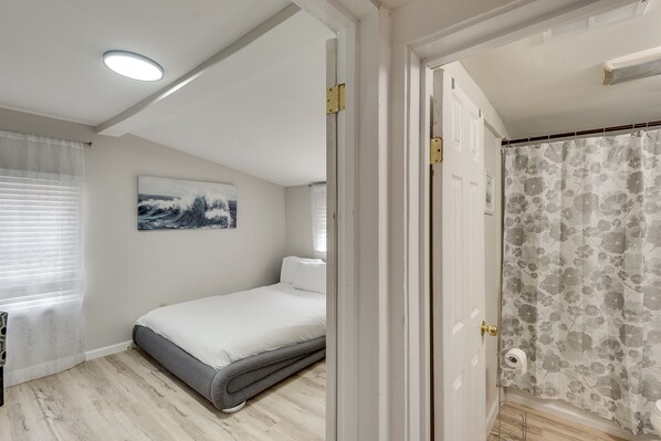 Une chambre à coucher avec un lit, un rideau de douche et un tableau accroché au mur.