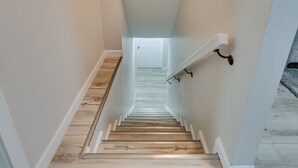 A staircase with a white railing, wooden steps, and a white door at the top. - ATL Oasis: Home Away From Home (Atlanta)