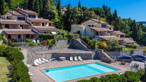 A hillside residential area with multiple houses, a swimming pool, and a stone staircase.