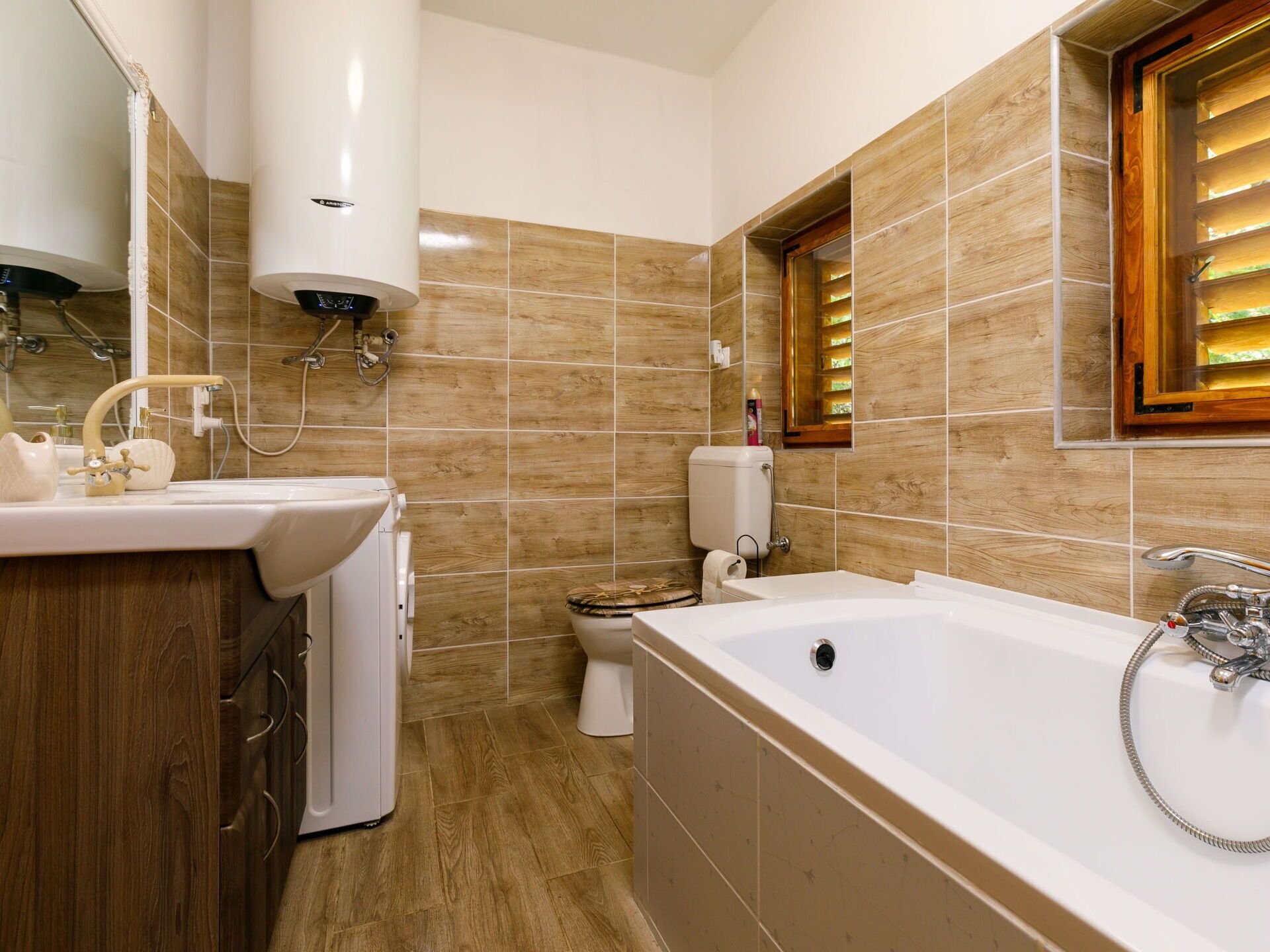 Ein modernes Badezimmer mit freistehender Badewanne, einem Waschbecken mit Unterschrank, einer Toilette und einer Duschkabine.