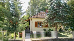 A house with a tiled roof, wooden shutters, and a small porch.