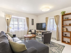 A modern living room with a sofa set, a coffee table, a television, and a bookshelf. - Stunning private villa for 6 people with WIFI, private pool, TV, terrace and pets allowed (Prague)