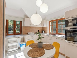 Uma cozinha moderna com ilha central, armários de madeira e forno embutido.