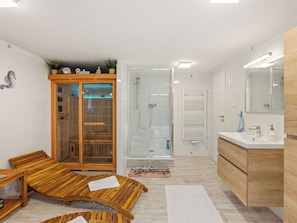 A modern bathroom with a glass-enclosed shower, wooden vanity, and a bench with a welcome mat. - Stunning private villa for 6 people with WIFI, private pool, TV, terrace and pets allowed (Prague)
