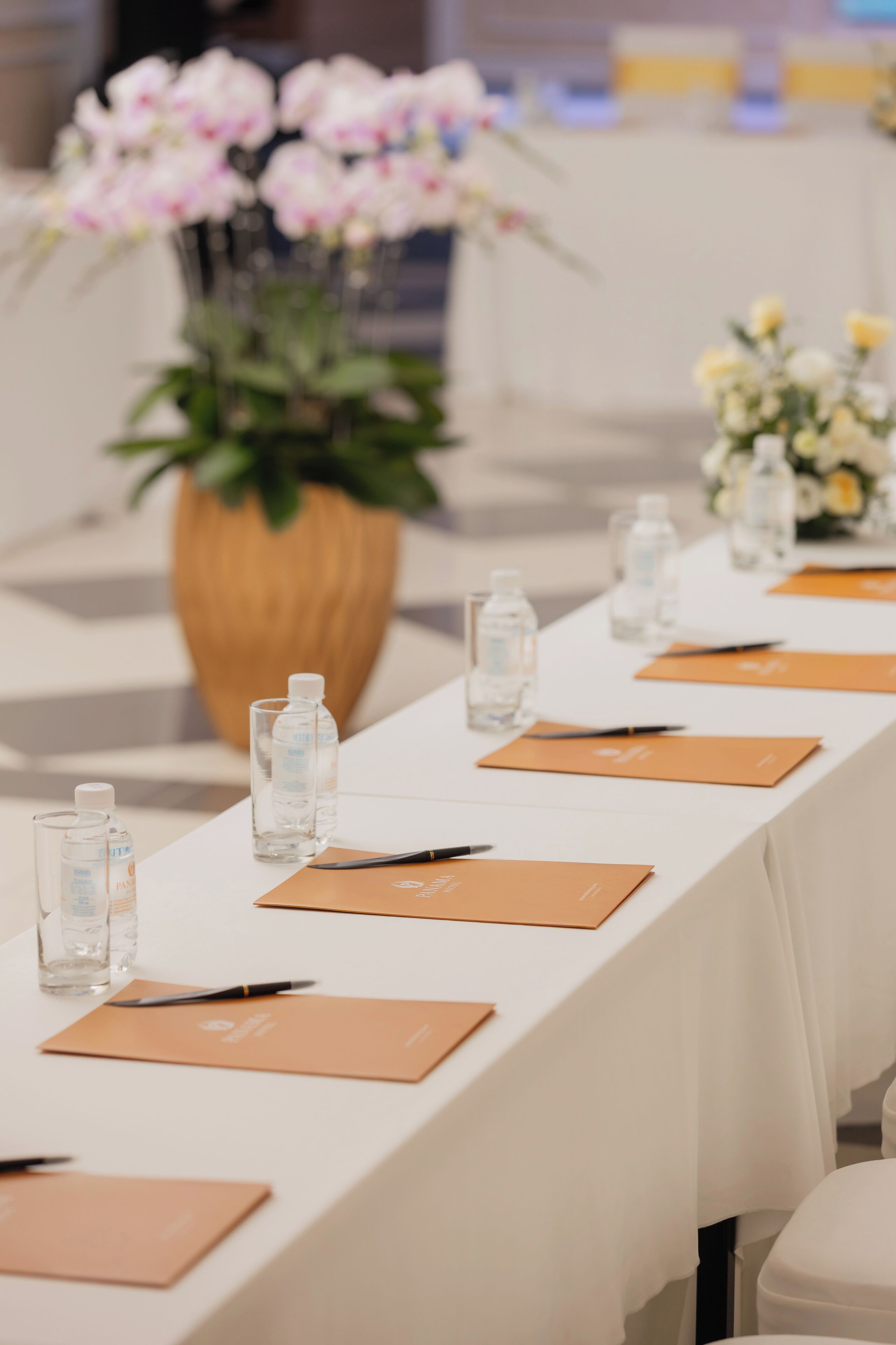 A conference table with water bottles, name cards, and pens.
