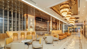 A spacious lobby with a bar area, seating arrangements, and a modern chandelier. - PANAMA Nha Trang Hotel (Nha Trang)
