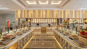 A buffet setup with multiple serving stations, a central serving area, and a variety of food items. - PANAMA Nha Trang Hotel (Nha Trang)