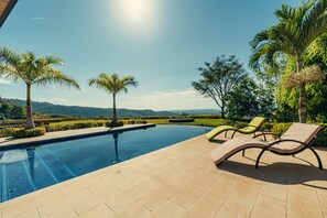 Relax by the pool surrounded by lush greenery and tranquil surroundings.