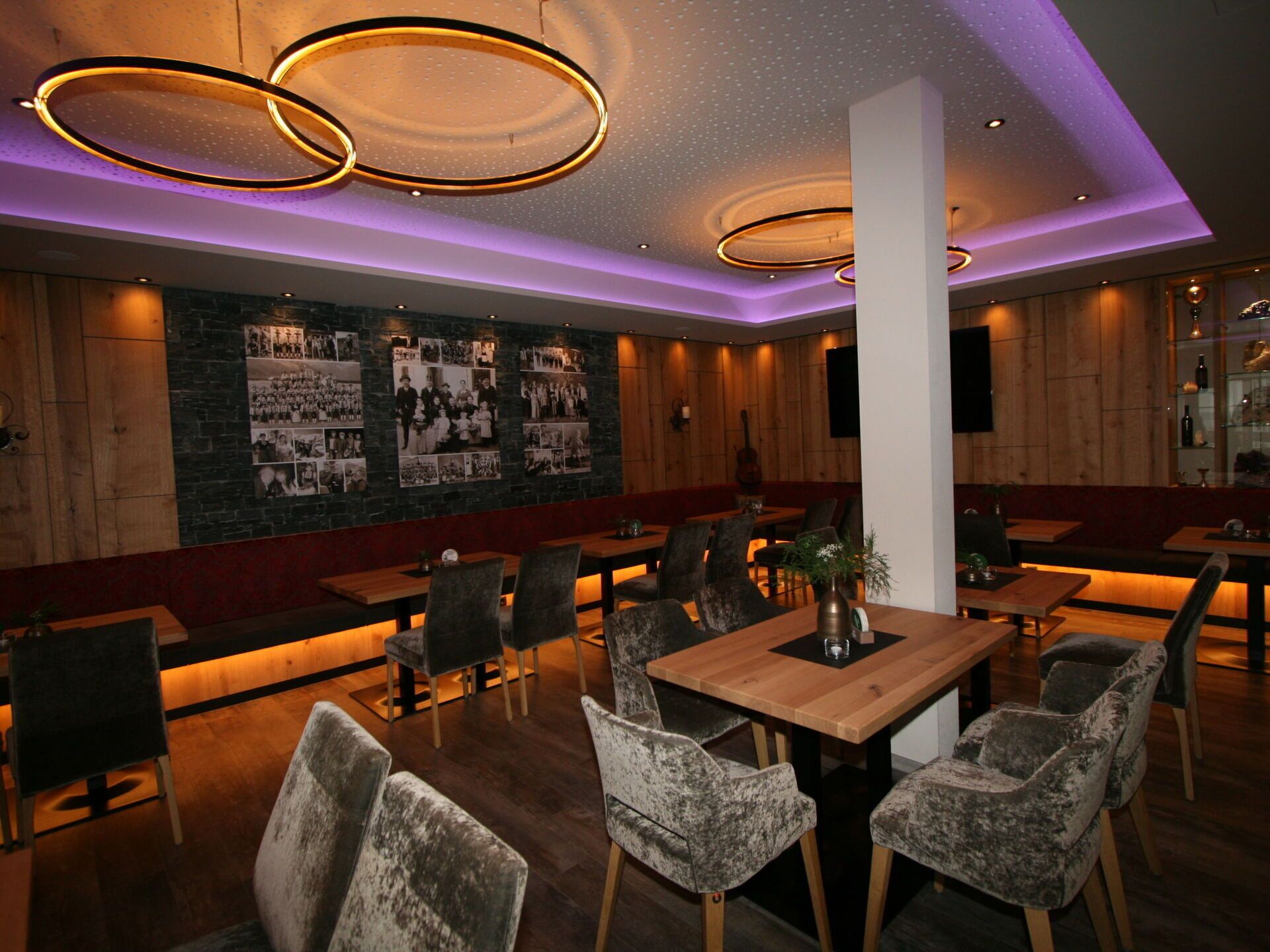 Un restaurant aux murs en bois, décoré de photographies en noir et blanc et doté d’un éclairage moderne.