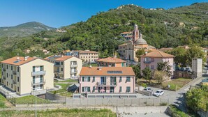 Un quartier résidentiel avec des bâtiments modernes, une église dotée d’un clocher et, au loin, une colline.