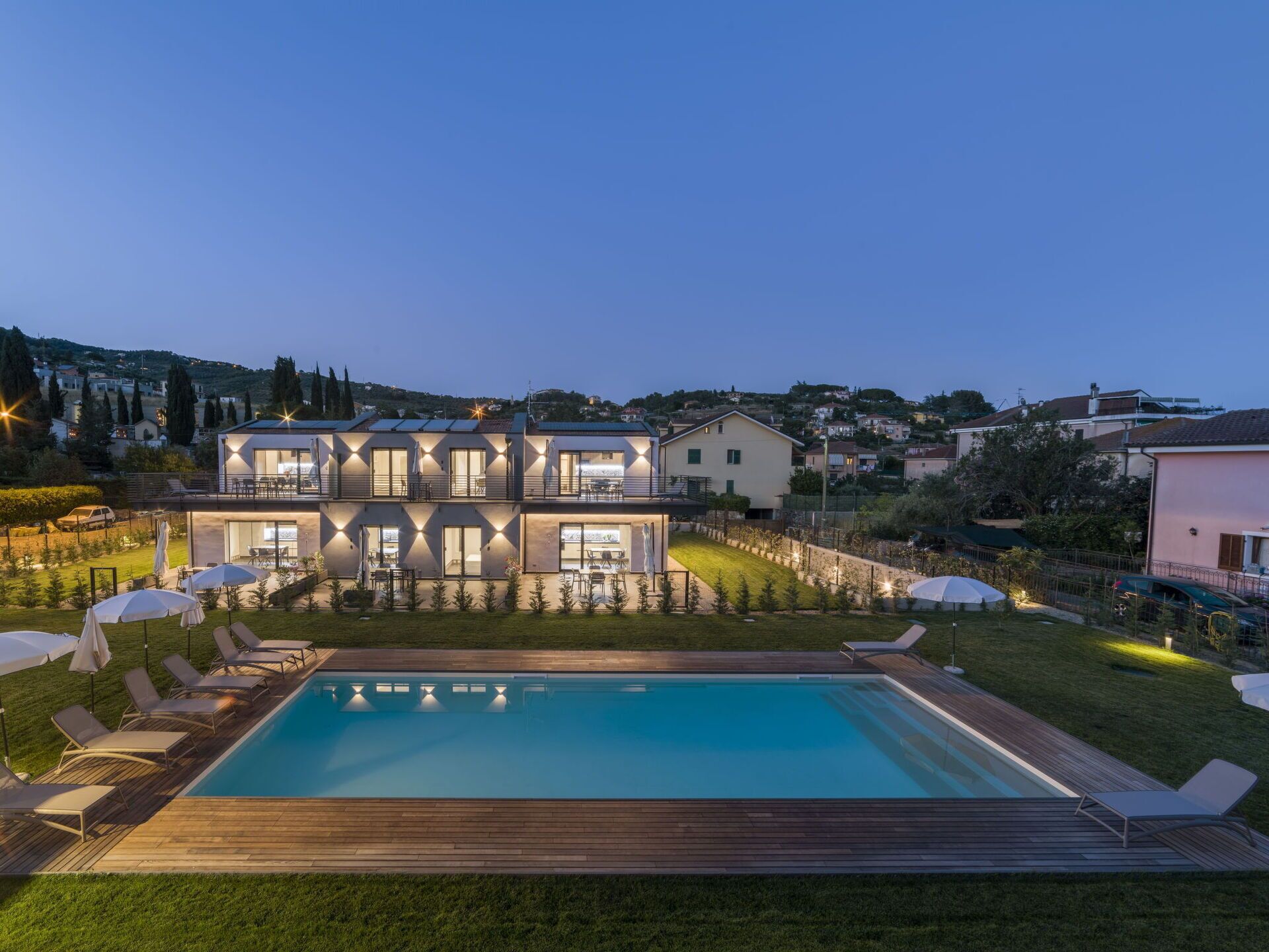Ein modernes, zweistöckiges Haus mit Swimmingpool, Außenbereich und Blick auf die umliegende Nachbarschaft.