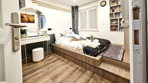 A modern bedroom with a bed, bedside table, mirror, and a small window. - Apartment - Sleeps 4 - Balcony - Near Metro Stn (Le Kremlin Bicetre)