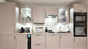 A compact kitchen with built-in appliances, a dishwasher, and a countertop with various items. - Apartment - Sleeps 4 - Balcony - Near Metro Stn (Le Kremlin Bicetre)
