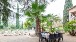 An outdoor dining area with a pool, surrounded by palm trees and a fence. - Beautiful apartment for 8 guests with WIFI, pool, TV, patio and pets allowed (Fréjus)