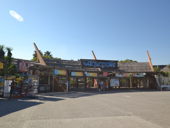 A building with a sign reading "Aquapolis" and a ticket booth.