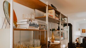A room with a wooden bookshelf filled with books and glassware.