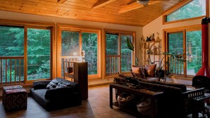 A spacious living room with large windows, a ceiling fan, and a cozy seating area.