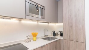 A modern kitchen with a stainless steel sink, a built-in oven, and wooden cabinetry.