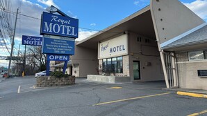 Motel Royal, con un letrero que indica la entrada y servicios como suites con jacuzzi, suites para lunas de miel e internet de alta velocidad.