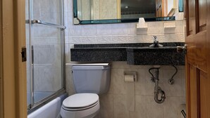 Un baño con inodoro, ducha y lavamanos.