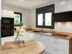 Mikrobølgeovn, ovn, oppvaskmaskin og høy barnestol