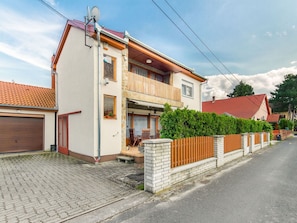 Une maison à deux étages avec un garage, un balcon et une allée pavée.