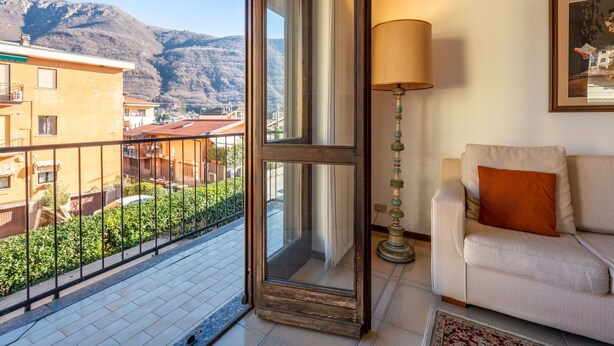 A balcony with a view of mountains, a sofa, a lamp, and a framed picture on the wall. - Beautiful apartment for 4 people with WIFI, TV, balcony and pets allowed (Nonio)