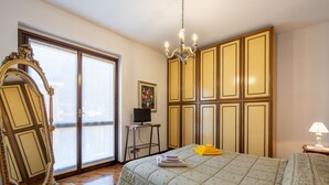 A bedroom with a large bed, a chandelier, a mirror, and a dresser. - Beautiful apartment for 4 people with WIFI, TV, balcony and pets allowed (Nonio)