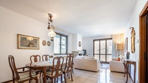 A spacious living area with a dining table, chairs, a sofa, and a TV. - Beautiful apartment for 4 people with WIFI, TV, balcony and pets allowed (Nonio)