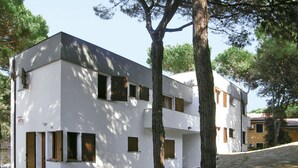 Un edificio moderno de dos plantas con techo plano y paredes exteriores blancas.