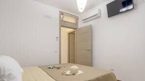Une chambre d’hôtel équipée d’un lit, d’un téléviseur fixé au mur et d’un appareil de climatisation.