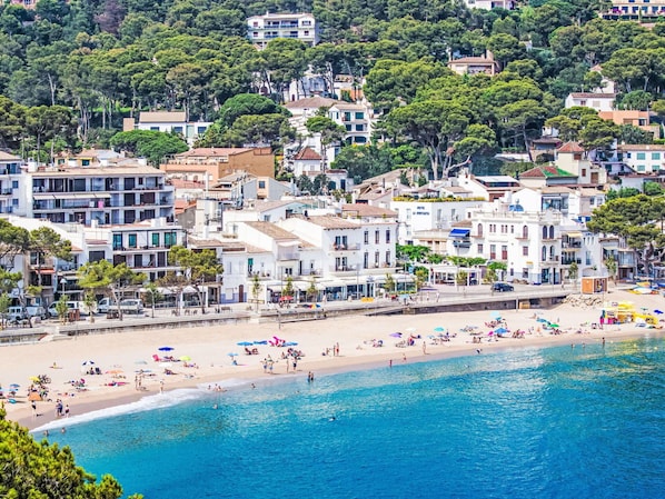 A coastal town with a sandy beach and a clear blue sea.