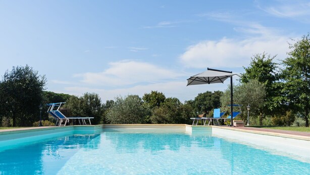 A clear blue swimming pool with a diving board and a shaded area. - Stunning private villa for 6 people with private pool, A/C, WIFI, TV, patio and pets allowed (Canale Monterano)