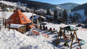 A snowy outdoor area with wooden structures, picnic tables, and a swing set. - Lovely apartment for 4 people with WIFI, TV, terrace, pets allowed and panoramic view (Dvur Králové Nad Labem)