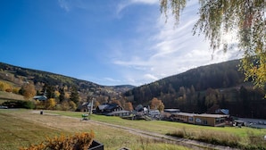 A rural landscape with houses, a paved area, and a view of the surrounding hills. - Lovely apartment for 4 people with WIFI, TV, terrace, pets allowed and panoramic view (Dvur Králové Nad Labem)