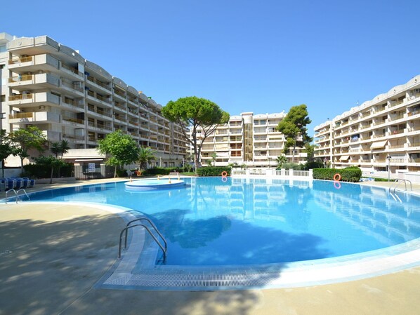 A swimming pool surrounded by multi-story residential buildings with balconies.