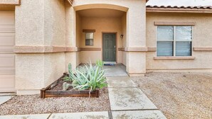 A house with a covered porch, a door, and a window with shutters. - Mesa Vacation Home - Sleeps 12 - Close to Golf Courses and SO MUCH MORE! (Mesa)