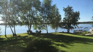 Un espacio verde con árboles y un muelle junto a un lago.