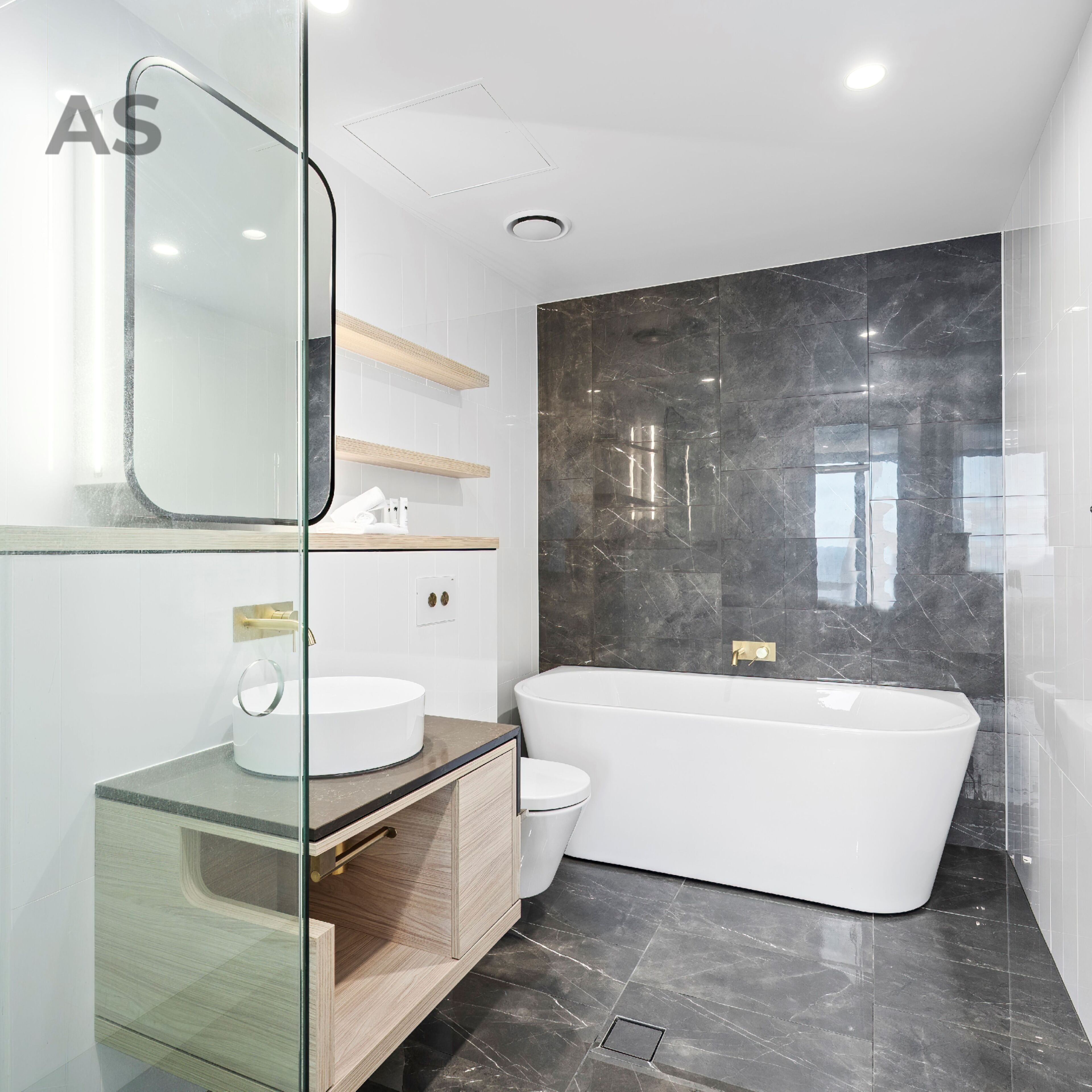 A modern bathroom with a freestanding bathtub, a glass-enclosed vanity, and a large mirror.