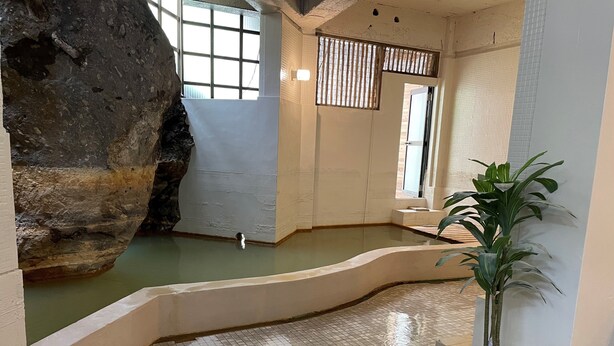 A spa area with a large rock formation, a small pool, and a potted plant. - yamanoyu (Kirishima)