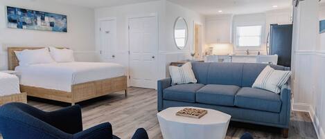 A modern bedroom with a bed, a blue sofa, and a white coffee table.
