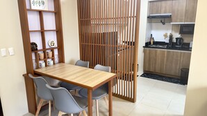 A modern kitchen with wooden cabinets, a black countertop, and a clock on the wall. - Stay comfy & feel Homealike 32 (Iloilo)