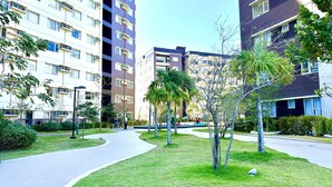 A residential complex with multiple apartment buildings, a central pedestrian pathway, and well-maintained greenery. - Stay comfy & feel Homealike 32 (Iloilo)