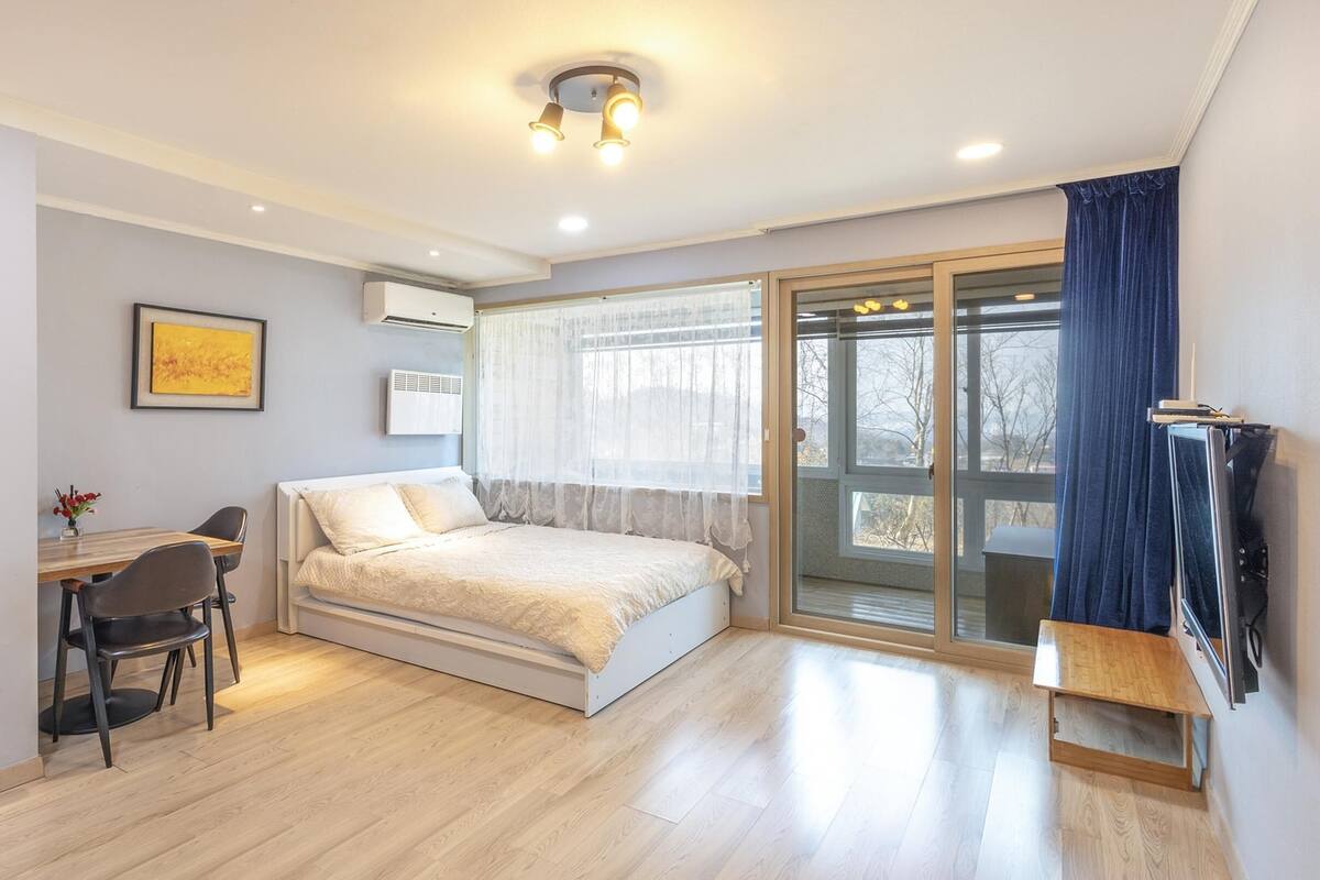 Ein modernes Schlafzimmer mit Bett, Schreibtisch und Stuhl.