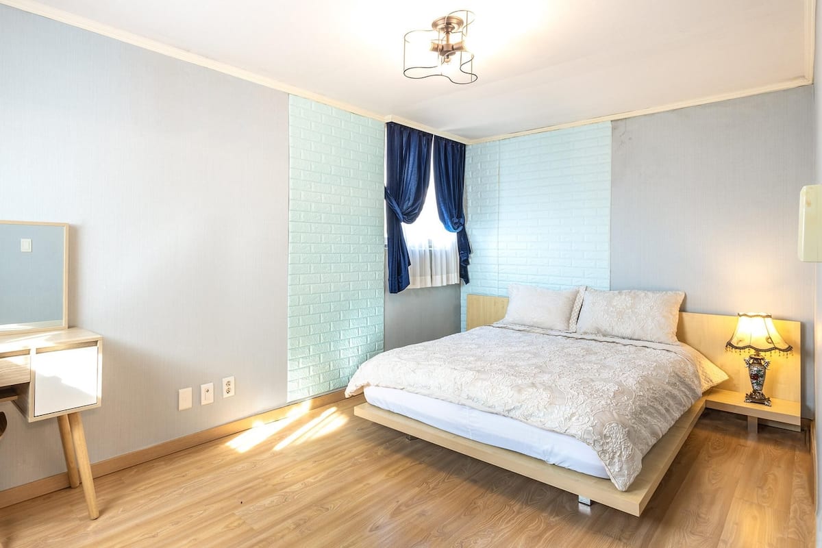 Ein Schlafzimmer mit Bett, Schreibtisch und Stuhl.