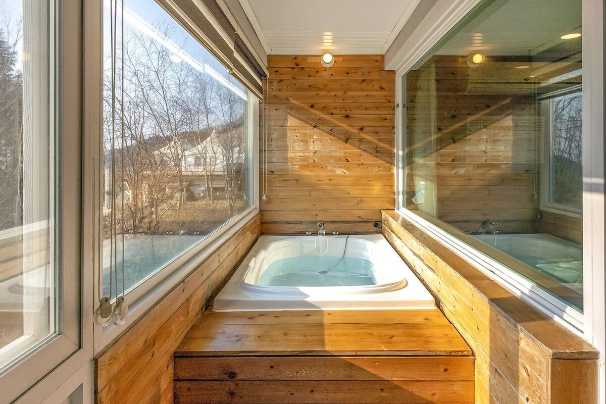 Ein Holzeinrichtung mit einer Badewanne und einem Fenster.